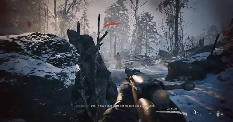 Vue à la première personne d’un soldat visant avec un fusil dans une forêt enneigée, sous le feu ennemi, avec des explosions au loin et une interface affichant les munitions et les grenades.