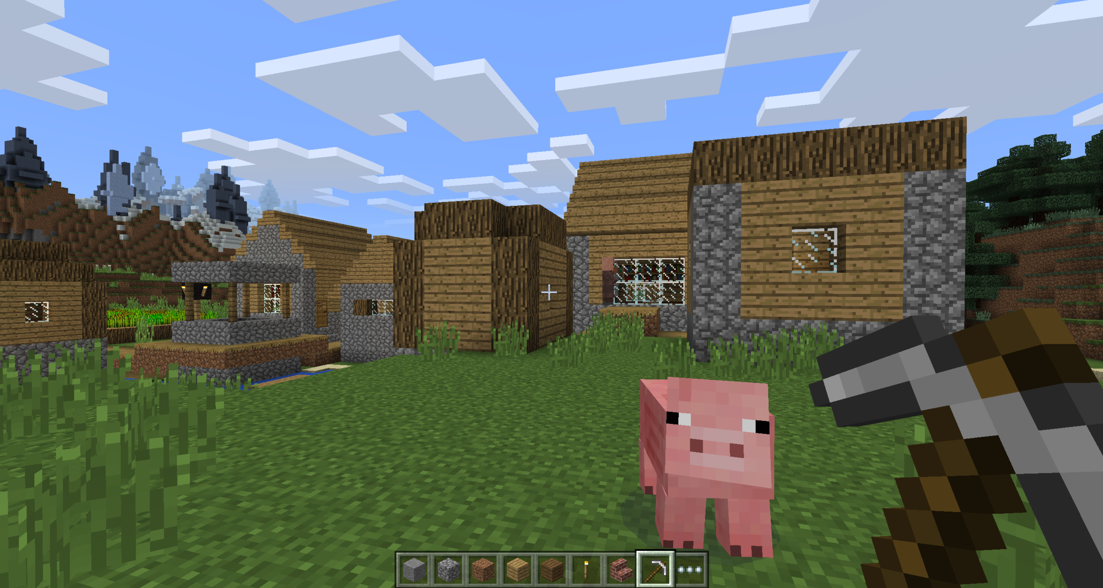 Capture d’écran du jeu Minecraft, montrant un village composé de maisons en bois et en pierre, situé dans une plaine verdoyante avec des montagnes en arrière-plan. Un cochon rose au style cubique est au premier plan, regardant le joueur. La main du joueur tient une pioche en bois, et la barre d’inventaire en bas affiche divers blocs et objets. Le ciel est bleu avec des nuages pixelisés, typiques du style graphique du jeu. Un villageois est visible à travers une fenêtre sur la droite.