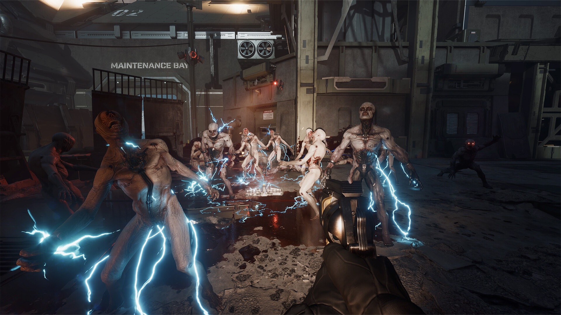Capture d'écran d'un jeu de tir à la première personne montrant un personnage qui combat des créatures mutantes dans un environnement sombre de type laboratoire. Plusieurs monstres, décharnés et mutilés, sont visibles autour du joueur. Certains des mutants sont traversés par des arcs électriques, accentuant leur aspect monstrueux. Les créatures ont des yeux rouges brillants, des corps déformés et une peau pâle. L'arrière-plan montre un espace industriel ou scientifique avec des équipements et des panneaux muraux, dont l'inscription "MAINTENANCE BAY" est visible. L'arme du joueur, un pistolet futuriste, est dirigée vers l'une des créatures. L'atmosphère est inquiétante, renforcée par des effets de lumière et un décor cybernétique post-apocalyptique.