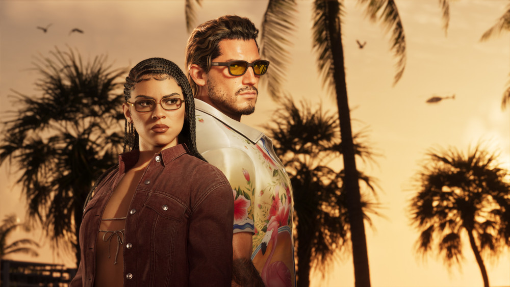 Visuel promotionnel d’un jeu vidéo montrant deux personnages debout dos à dos devant des palmiers au coucher du soleil. La femme, aux cheveux tressés et portant des lunettes, regarde vers la gauche avec une veste ouverte, tandis que l’homme, barbu, en chemise à motif floral et lunettes de soleil teintées, regarde vers la droite. Un hélicoptère apparaît au loin dans un décor évoquant une ville côtière tropicale.