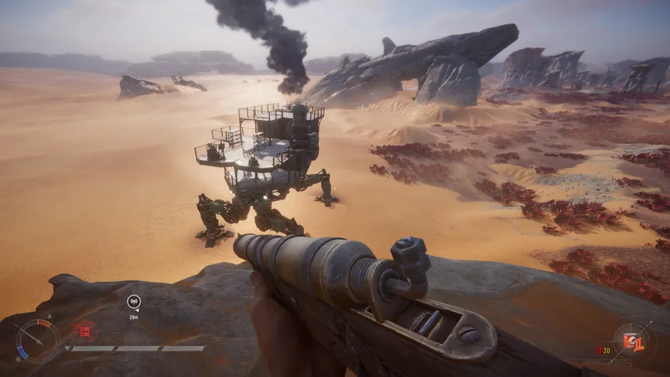 Capture de jeu en vue à la première personne dans un vaste désert extraterrestre. Le joueur tient une arme à feu face à un grand véhicule marcheur mécanique dégageant une épaisse fumée noire, tandis que d’imposantes formations rocheuses et une végétation rougeâtre s’étendent à l’horizon.
