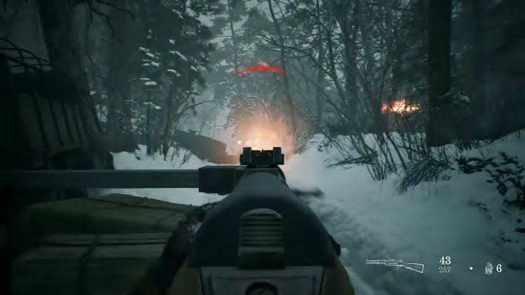 Vue à la première personne d’un soldat avançant avec un fusil à verrou dans une forêt enneigée ravagée par les combats, avec des ennemis visibles au loin, une indication de dégâts en rouge et l’interface des munitions affichée à l’écran.