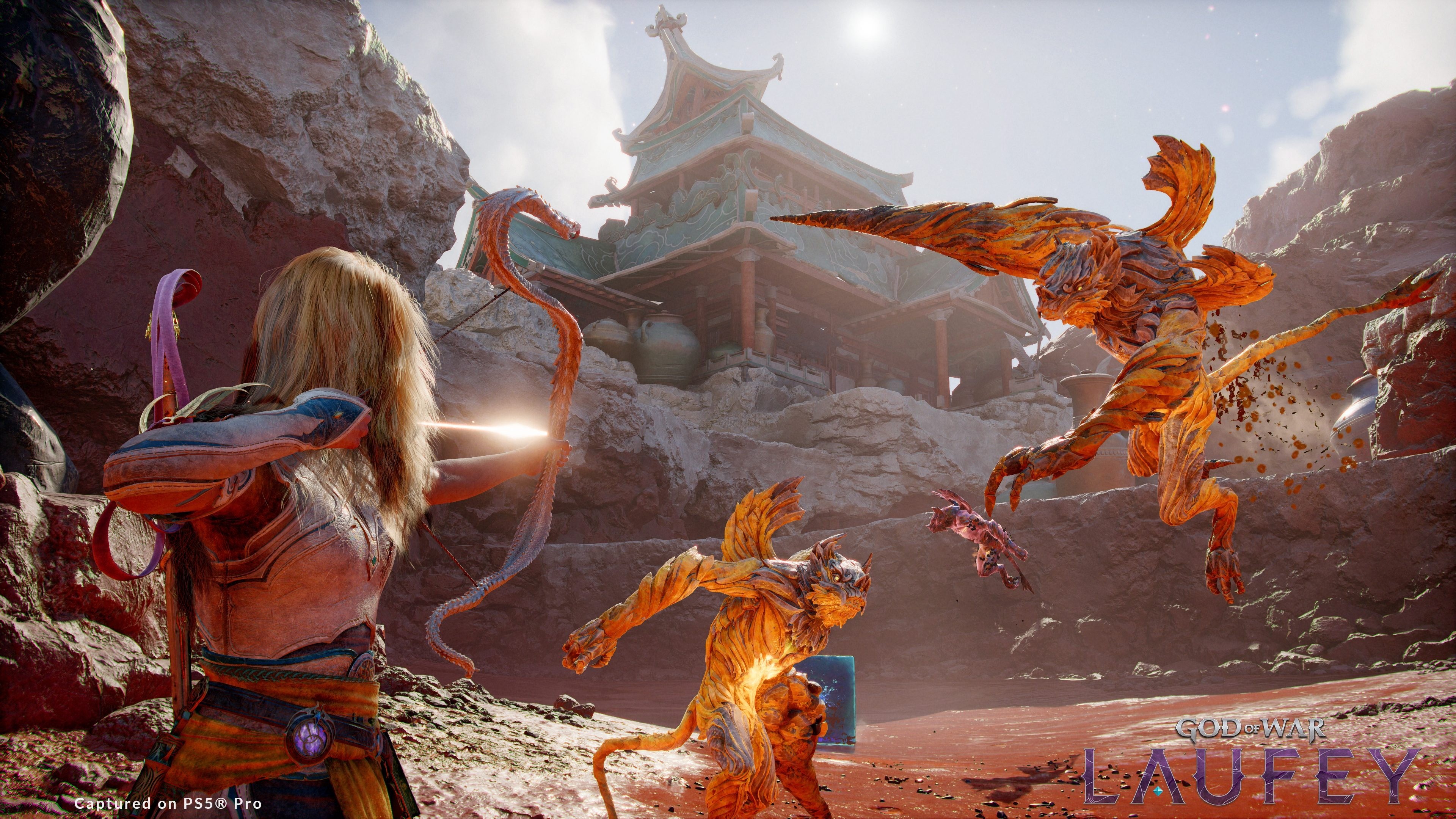 Capture de God of War: Laufey sur PS5 Pro montrant une archère blonde bandant son arc face à plusieurs créatures orangées qui bondissent vers elle, dans une arène rocheuse dominée par un temple d’inspiration asiatique.
