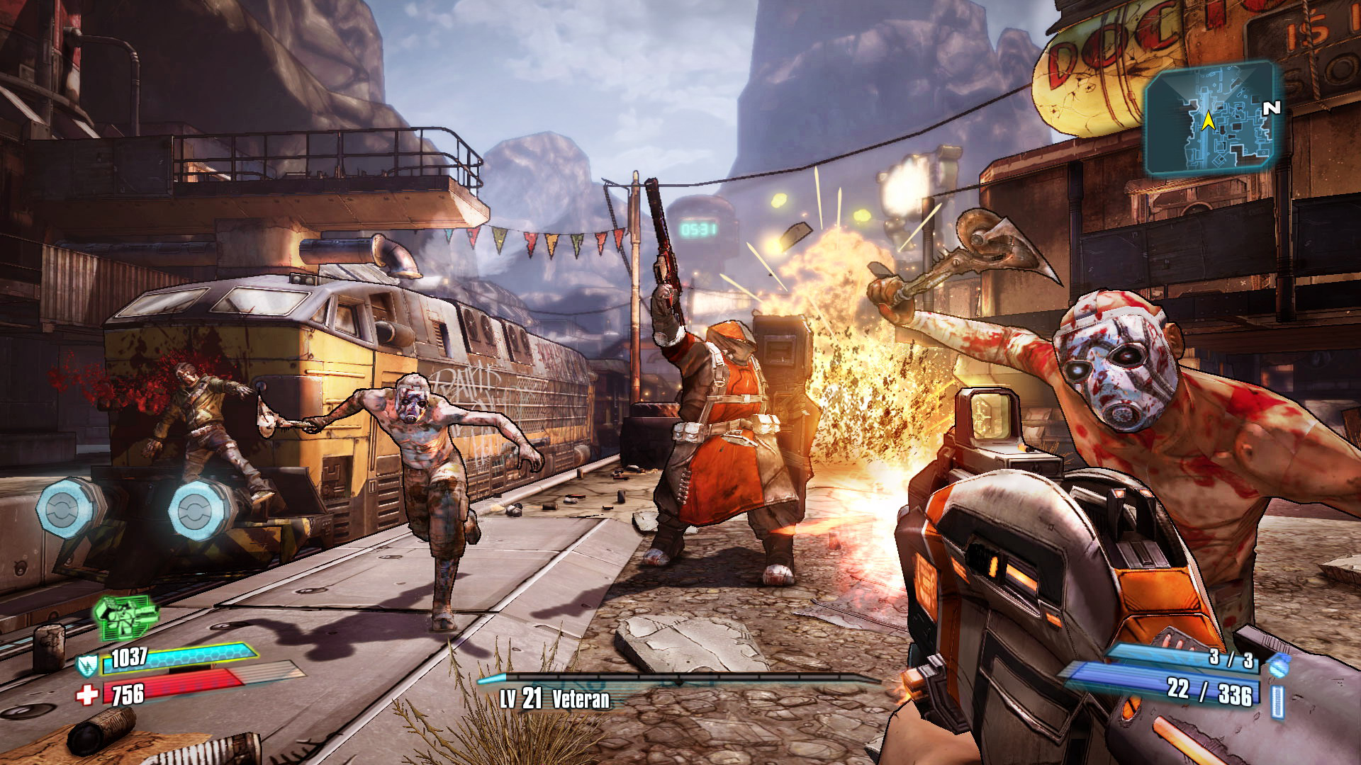 Capture d’écran dynamique du jeu Borderlands 2, illustrant une scène de combat chaotique et stylisée dans un environnement industriel désertique. Vue à la première personne, le joueur tient un fusil d’assaut futuriste orange et gris, visant un groupe d’ennemis agressifs. Au premier plan, un bandit torse nu, couvert de sang, portant un masque blanc au style sadomasochiste, bondit vers le joueur avec une hache levée. En arrière-plan, une explosion éclaire la scène, projetant flammes et débris, tandis que d’autres ennemis — dont un grand personnage en manteau rouge armé d’un fusil, et plusieurs bandits mutants à l’apparence déformée — avancent depuis une zone située devant une vieille locomotive jaune couverte de graffitis. L’environnement combine éléments urbains délabrés, structures en métal, montagnes et pancartes post-apocalyptiques. Une mini-carte en haut à droite et l’interface utilisateur en bas à gauche (barres de vie, bouclier, munitions, niveau 21 "Veteran") soulignent l’aspect RPG et looter shooter du gameplay. Le style graphique en cel-shading et les couleurs saturées renforcent l’identité visuelle unique de Borderlands 2, un mélange de science-fiction, d’humour noir et d’action frénétique dans un univers anarchique.