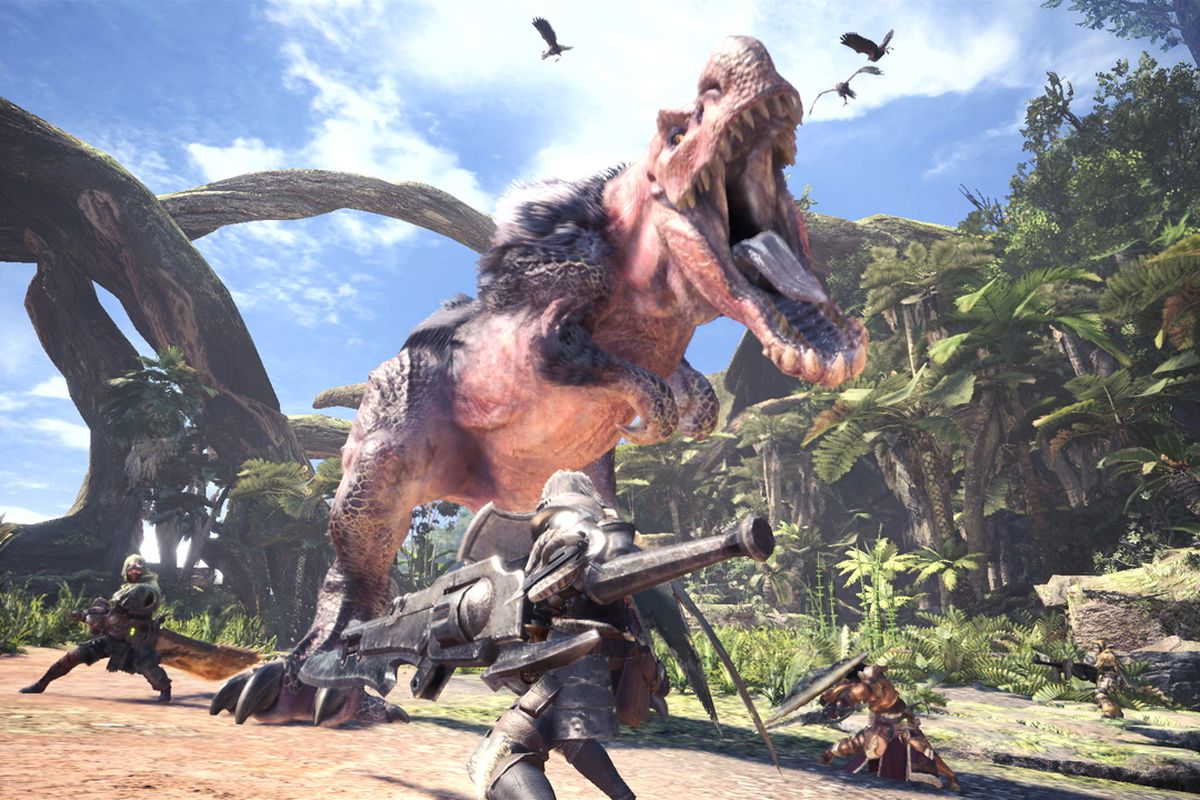 Scène spectaculaire tirée du jeu Monster Hunter: World, montrant un affrontement entre plusieurs chasseurs lourdement armés et un monstre gigantesque dans un environnement de jungle luxuriante. Au centre, un immense dinosaure aux allures de T-Rex, l’Anjanath, rugit avec férocité, la gueule grande ouverte, révélant des crocs acérés et une langue visqueuse. Sa peau rosée et écailleuse est partiellement recouverte de fourrure noire sur le dos, accentuant son aspect sauvage. Au premier plan, un chasseur en armure métallique brandit une immense arme hybride entre une épée et un fusil, prêt à frapper. À droite, un autre combattant en position défensive tient un bouclier, tandis qu’à l’arrière, deux autres membres de l’équipe approchent avec des armes imposantes. Le combat a lieu sur un sentier bordé de végétation dense, sous un ciel bleu éclatant, avec de gigantesques arbres aux lianes suspendues en arrière-plan. Des oiseaux s’envolent au-dessus de la scène, amplifiant la tension et l’ampleur du combat. L’image incarne parfaitement l’essence de Monster Hunter: World : des batailles coopératives intenses contre des créatures colossales, dans un monde ouvert vivant et magnifiquement détaillé.