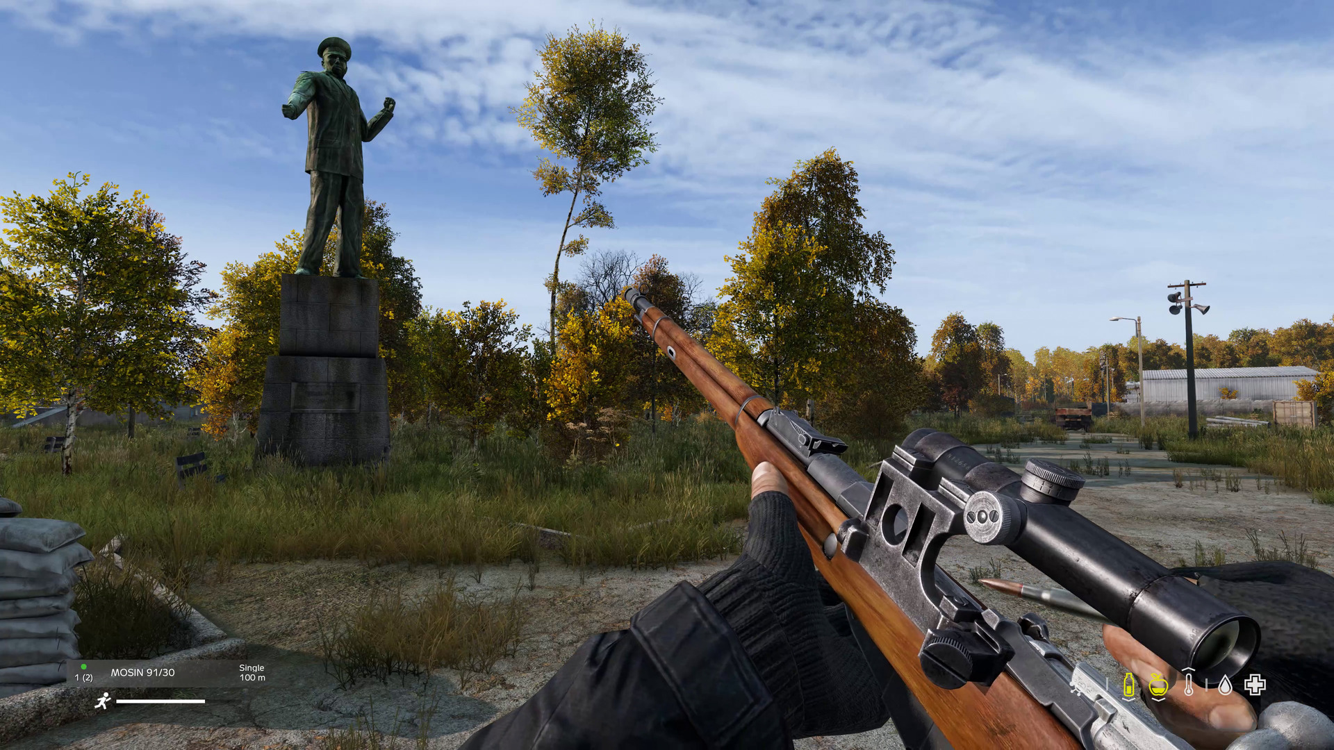 Capture d’écran de DayZ montrant une vue à la première personne avec un fusil à lunette tenu devant une place abandonnée et envahie par la végétation. Une grande statue domine le décor, entourée d’arbres d’automne, de bâtiments délabrés et d’une interface de survie visible en bas de l’écran.