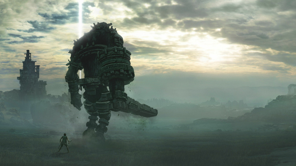Illustration emblématique du jeu Shadow of the Colossus, montrant une confrontation entre un jeune héros et un gigantesque colosse dans une vaste plaine brumeuse. Au premier plan, le protagoniste, armé d'une épée, se tient face à l'immense créature, dont l’apparence mélange pierre, métal et fourrure. Le colosse, imposant et quadrupède, est partiellement recouvert d’armures gravées de motifs anciens, et une lumière divine jaillit de son crâne vers le ciel nuageux. À gauche, une ruine monumentale émerge du brouillard, accentuant le sentiment de mystère et de solitude de l’environnement. L’ambiance générale est dramatique et mélancolique, soulignée par la lumière diffuse du coucher ou lever de soleil, avec des tons gris, verts et dorés qui amplifient la grandeur et la gravité de la scène.