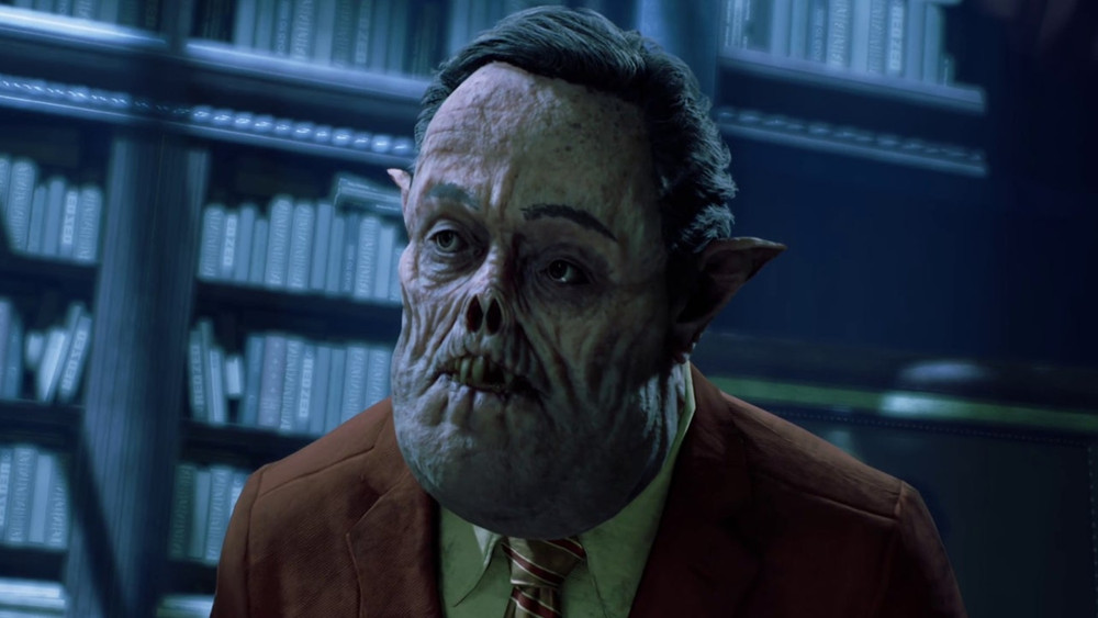 Personnage inquiétant issu d’un jeu vidéo, représenté dans un environnement intérieur aux allures de bibliothèque sombre et luxueuse. La créature humanoïde arbore un visage grotesquement déformé, sans nez apparent, avec une peau plissée, des oreilles pointues et un regard vide. Elle est habillée de manière élégante avec un costume rouge bordeaux, une chemise verte pâle et une cravate rayée, contrastant avec son apparence monstrueuse. L’arrière-plan montre des étagères remplies de livres, renforçant une atmosphère mystérieuse et surnaturelle, typique d’un univers de vampire ou d’horreur urbaine, comme celui de Vampire: The Masquerade – Bloodlines 2.