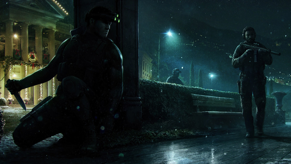 Visuel promotionnel de Splinter Cell montrant Sam Fisher accroupi dans l’ombre derrière un pilier, un couteau à la main et son emblématique dispositif de vision nocturne à trois lentilles allumé sur le front. Deux soldats armés patrouillent dans un jardin devant un bâtiment officiel illuminé pour les fêtes, sous une pluie nocturne qui renforce l’atmosphère d’infiltration.